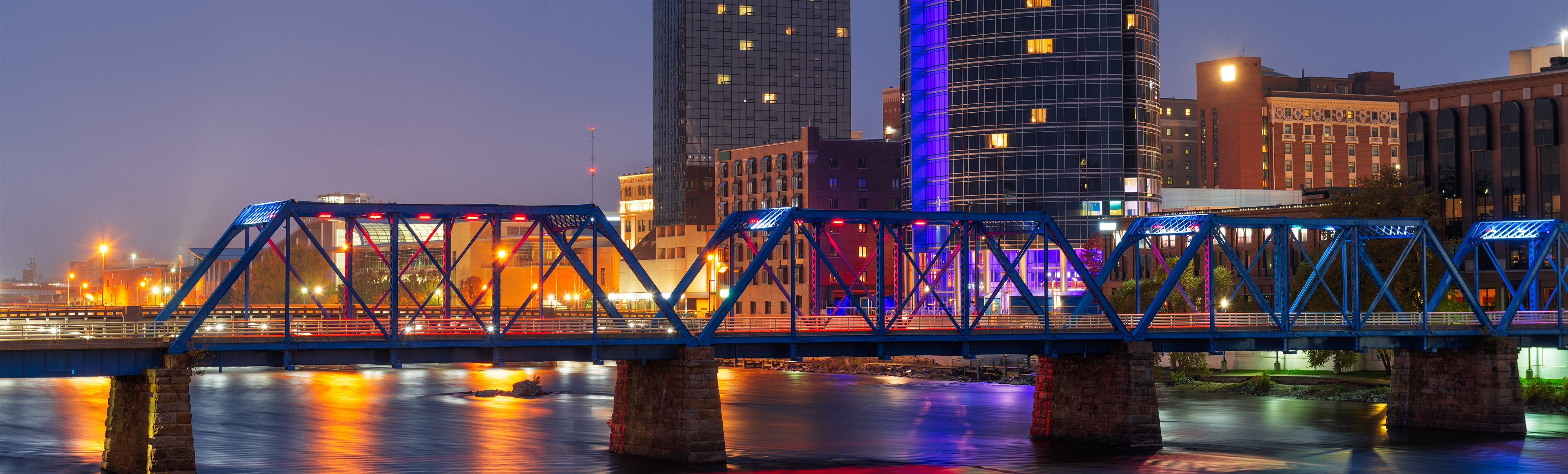 Retirement planning in grand rapids michigan, downtown skyline on the grand river at dusk.